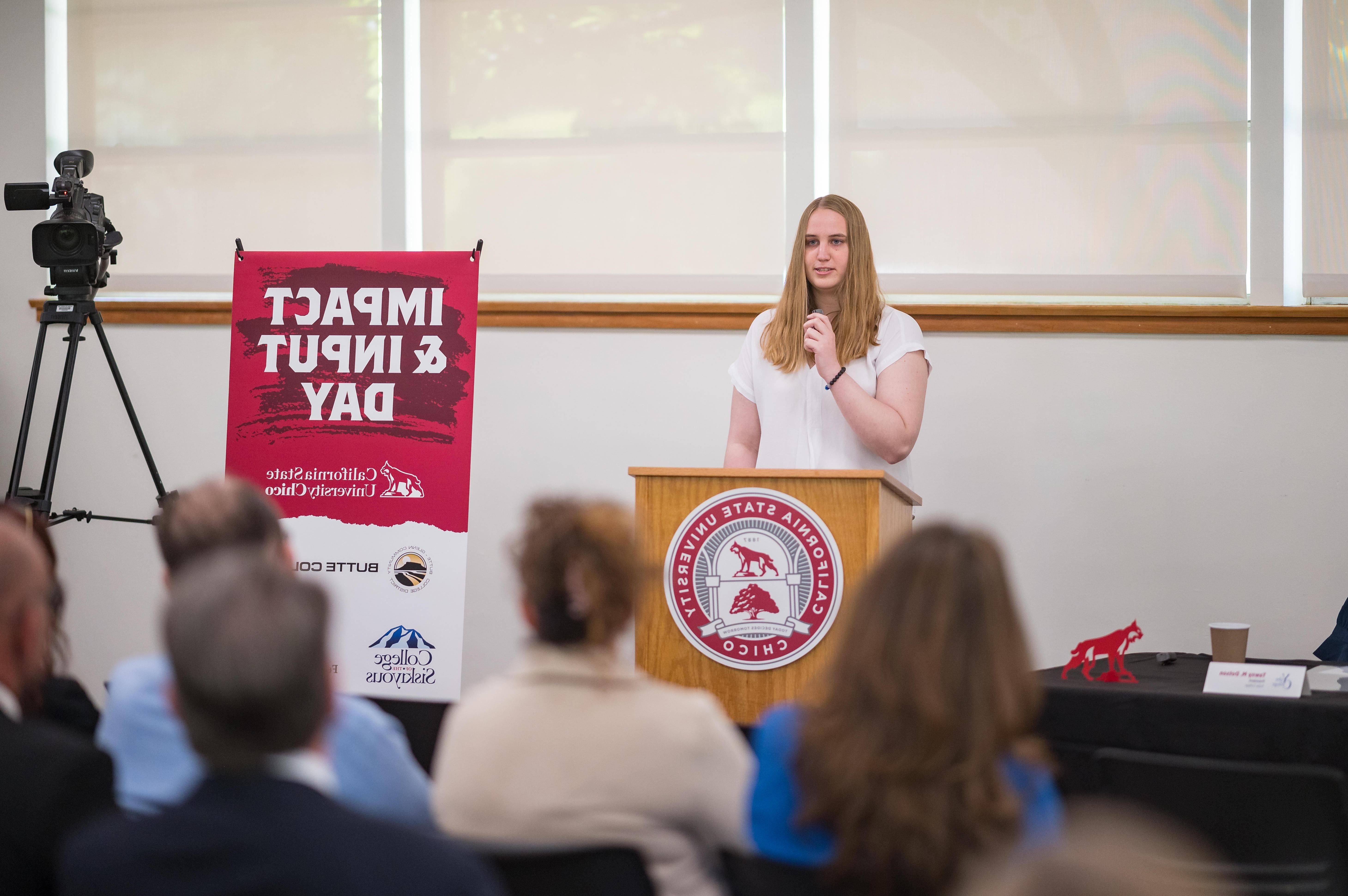 A Butte College transfer student is show speaking at a podium.